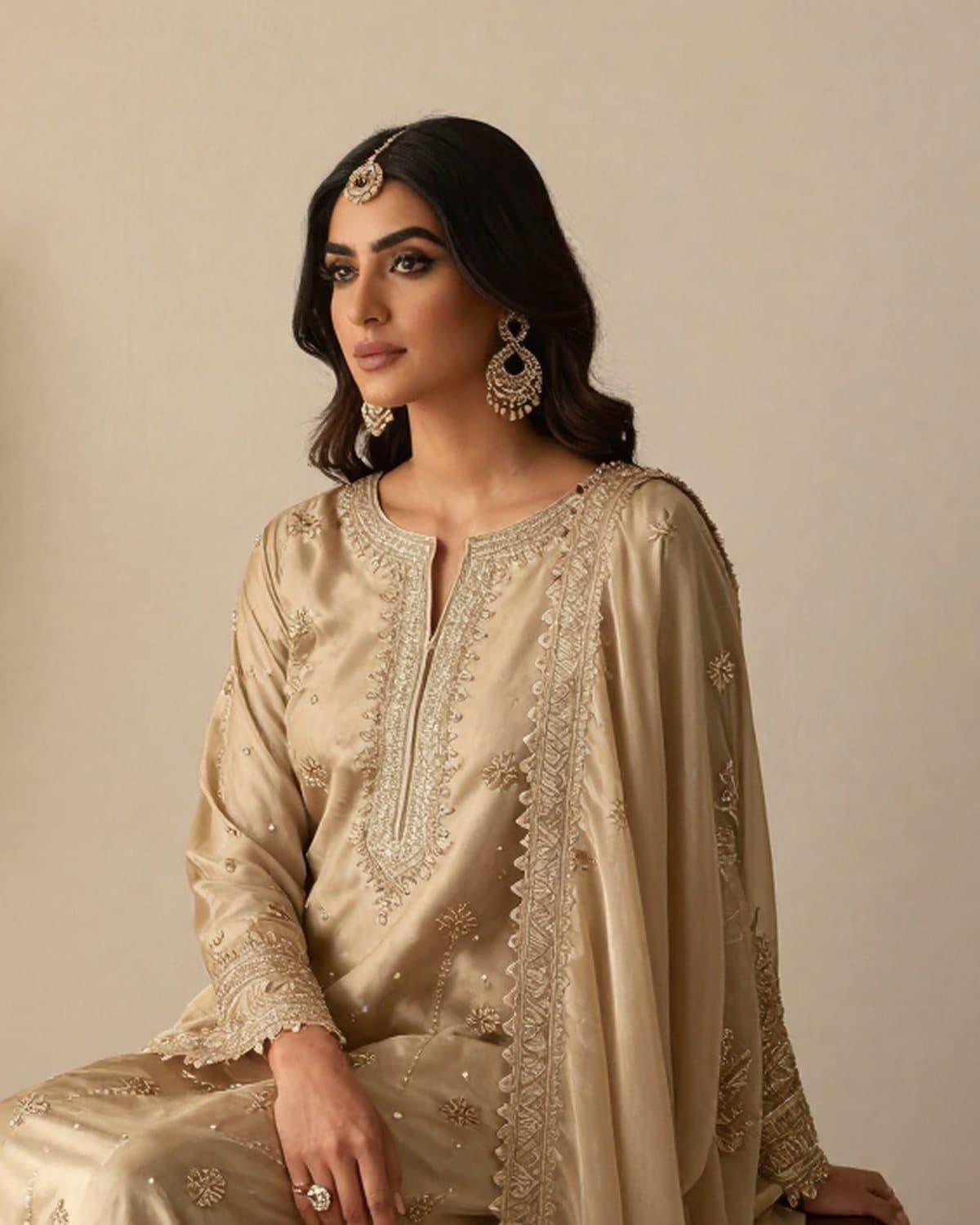 Close view of zari work across the neckline of a champagne formal